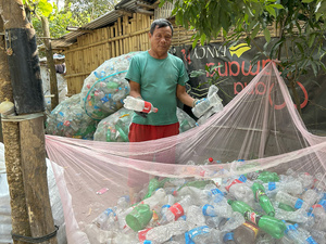 Bhutanese refugee  Amber Bahadur Jogi organizes the waste he has collected in his storage facility located within a refugee settlement in eastern Nepal. 