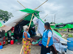 UNHCR staff talks with an elderly survivor of the Myanmar earthquake.