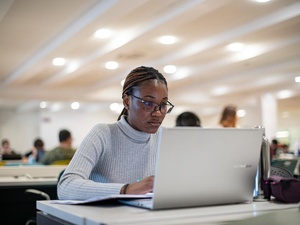 A student studies on her laptop in a university library