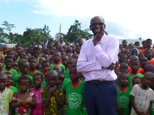 Mohamed Askia Touré, UNHCR's representative in Côte d'Ivoire, among a sea of children in an Ivorian village
