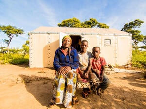 Tanzania. Velarie Ntahonicaye and her family with their Refugee Housing Unit (RHU) in Kigoma refugee Camp