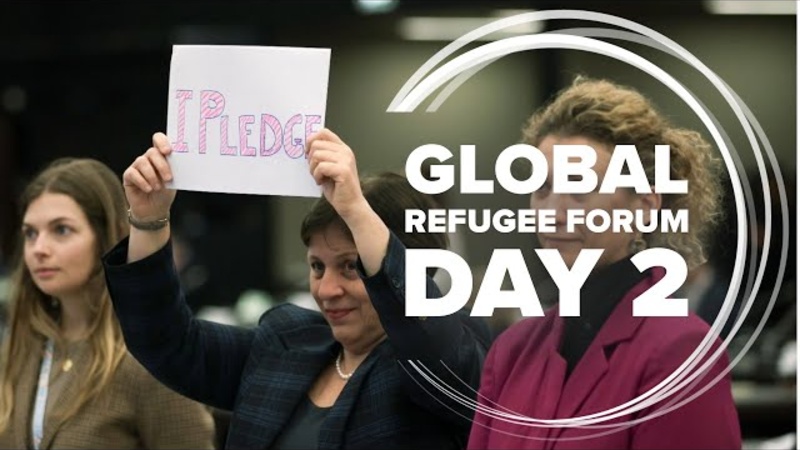 A woman holds a sign reading "I pledge".
