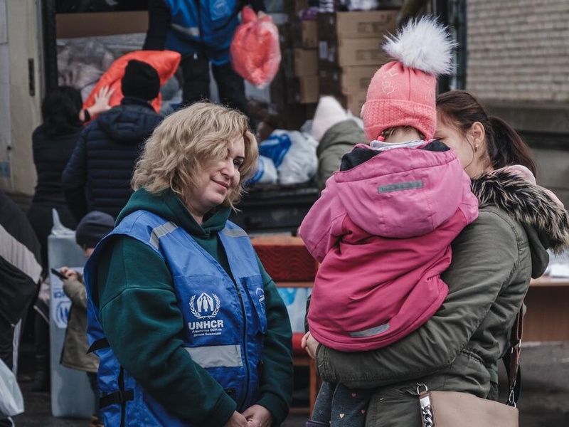 Anzhela (24) holds her little niece Liliya (4) as they wait to receive warm clothes and blankets.