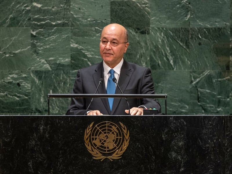 Barham Salih, wearing a suit, speaks at a podium bearing the United Nations emblem