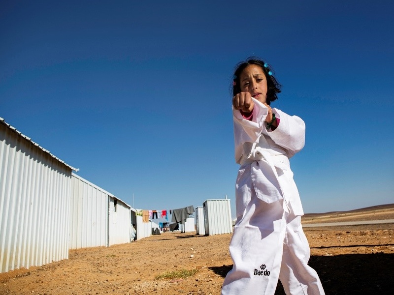 A young girl practices karate moves.