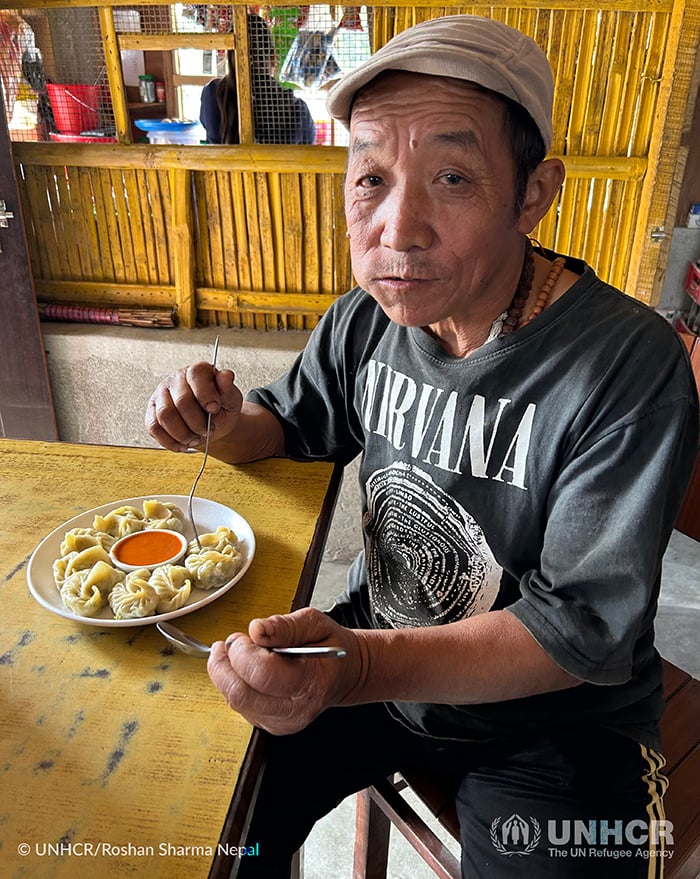 Gunaraj&rsquo;s father Kulman Sampang Rai enjoys vegetable dumplings as he talks about his story of fleeing Bhutan.