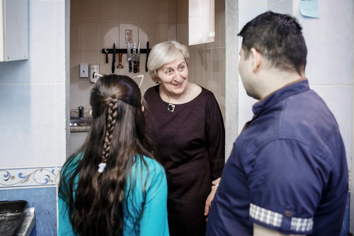 Belarus. A former Georgian refugee shows the kitchen of her own café to a Syrian refugee chef