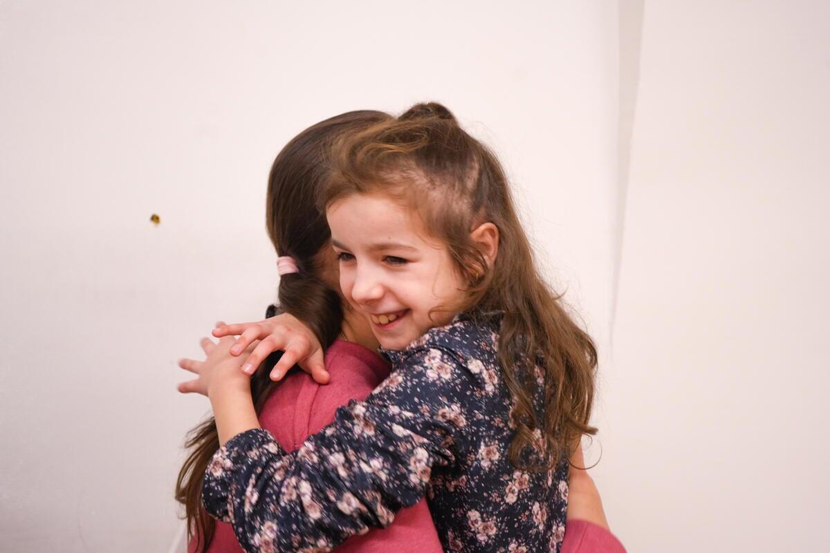 María abraza a su madre Liudmyla, quien afirma que las sesiones con Noir han tenido un impacto positivo en su hija.