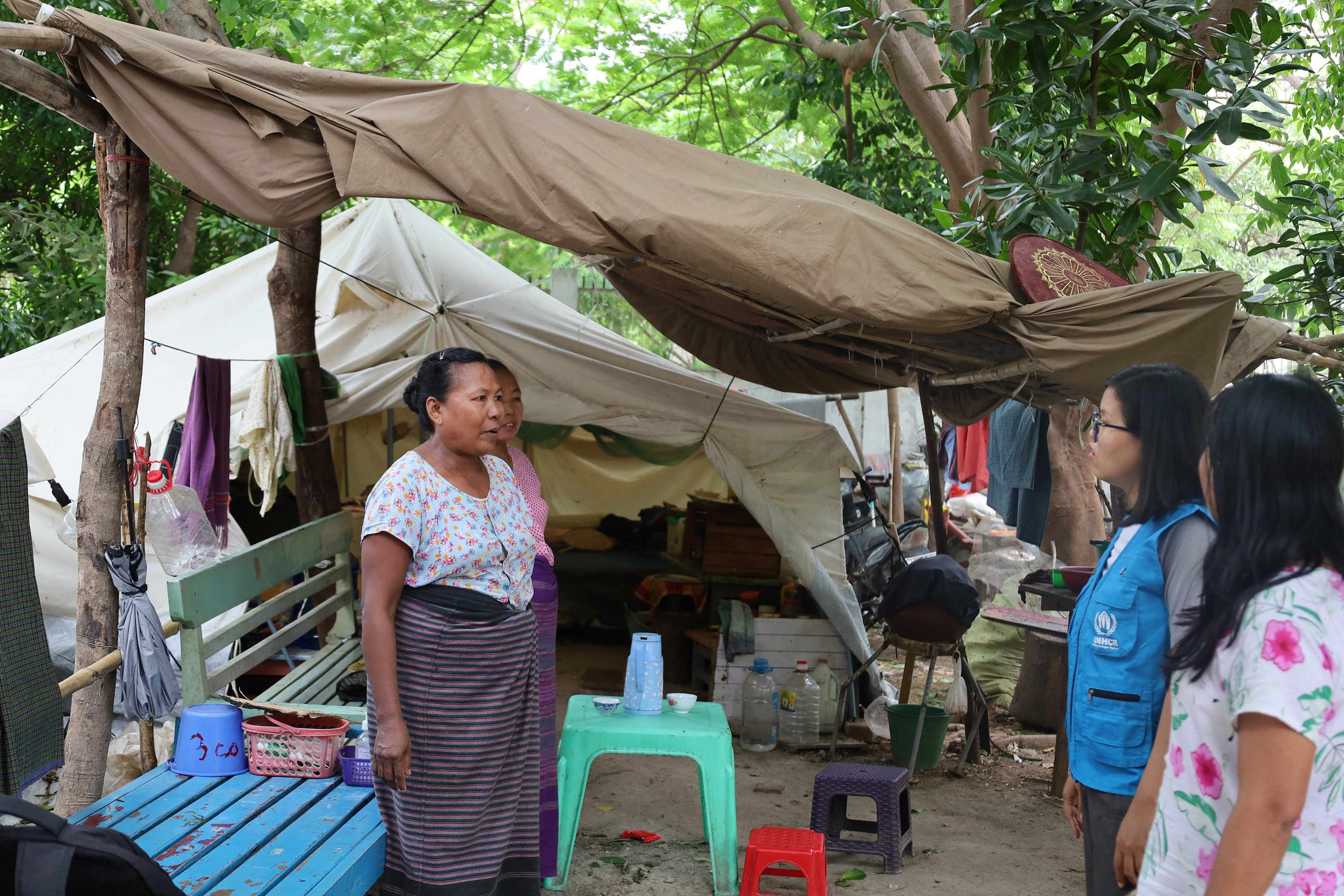 Daw Swe Win speaks with UNHCR staff in an area where family tents have been set up for her and many others, receiving support as they begin setting up their new shelter and restarting their daily routines.