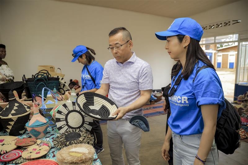 Mr. Yamada with UNHCR staff looking at crafts created by refugees.