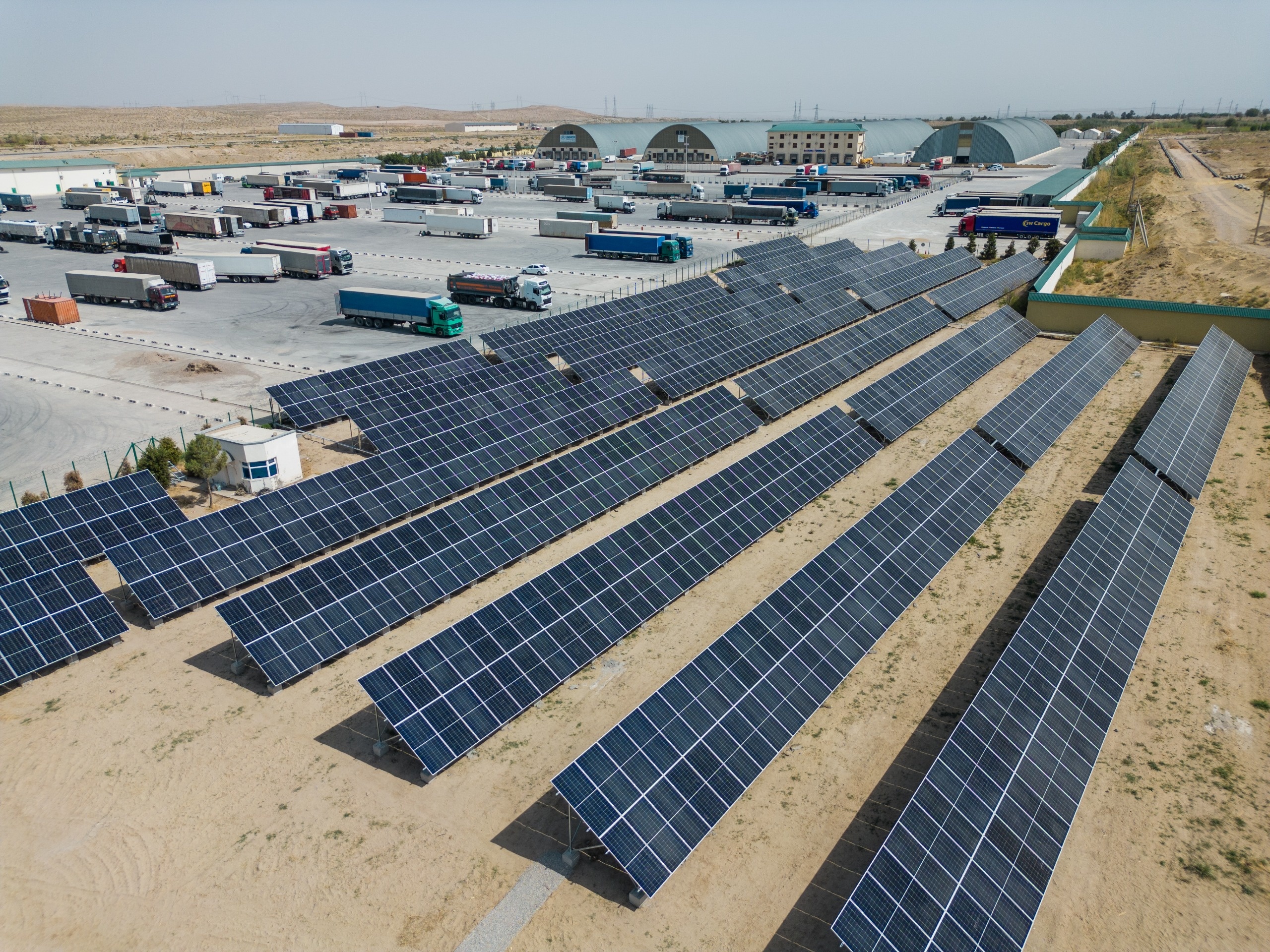 Six rows of large solar panels on a sunny day.