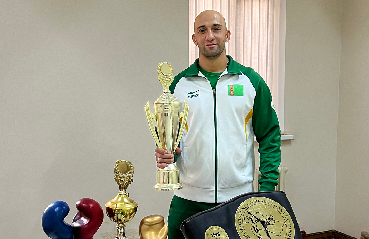 Mustafa poses with his kickboxing trophies and medals.