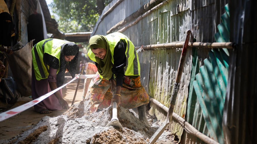 Rohingya refugee women in Cox's Bazar refugee camp working together to pave alleyways.