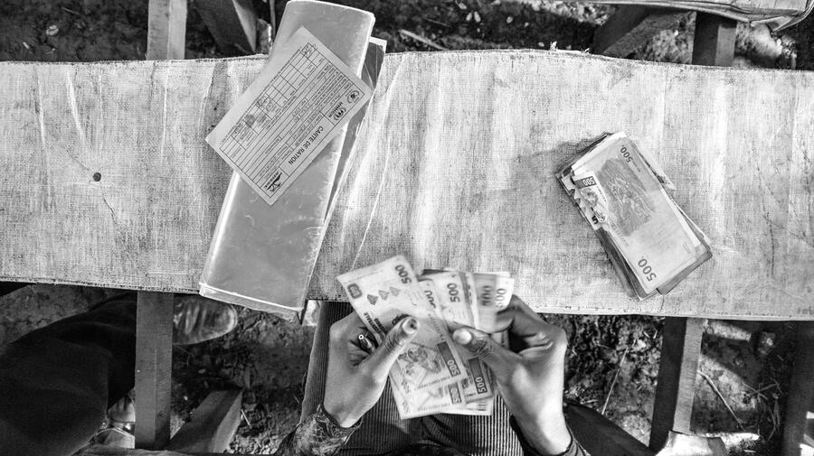 A refugee from Central African Republic checks the money she received for four people during a cash grant distribution in Mole camp, northern Democratic Republic of the Congo.