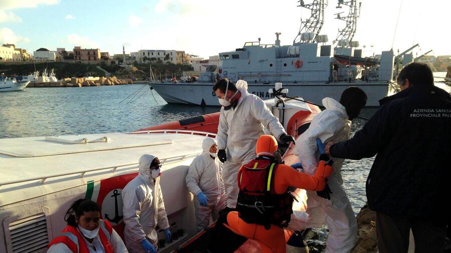 Italy.  Italian coastguards arrive with survivors of a boat tragedy in the Mediterranean