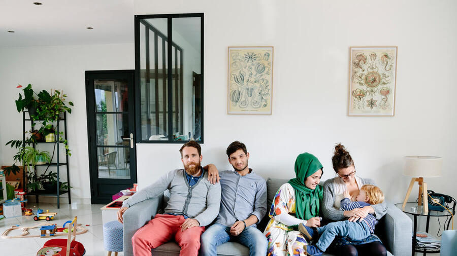 France. Anaïs, Vincent, and their son César, host Afghan refugees Zulfeqar and Battarine, in Saint-Priest. This portrait is part of the No Stranger Place series, which portrays locals and refugees living together