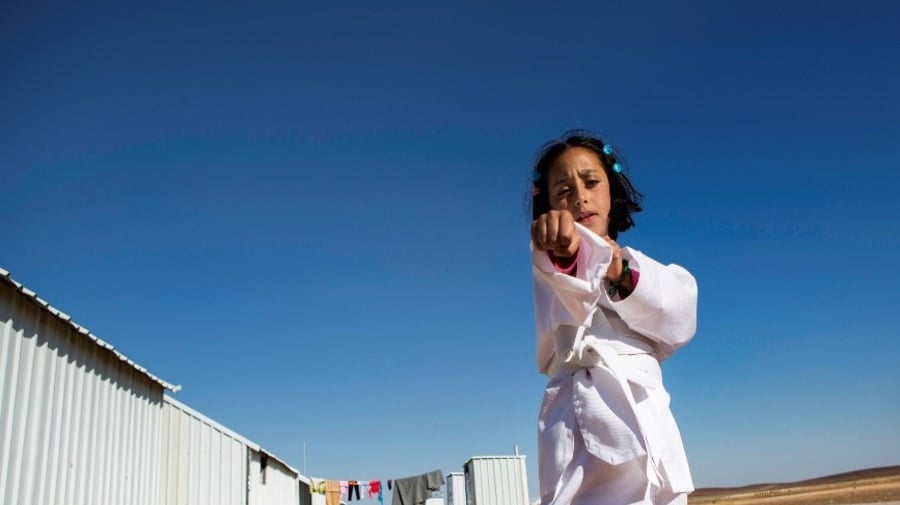 A young girl practices karate moves.