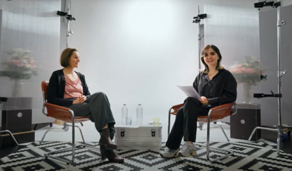 Zwei Frauen sitzen einander gegenüber.