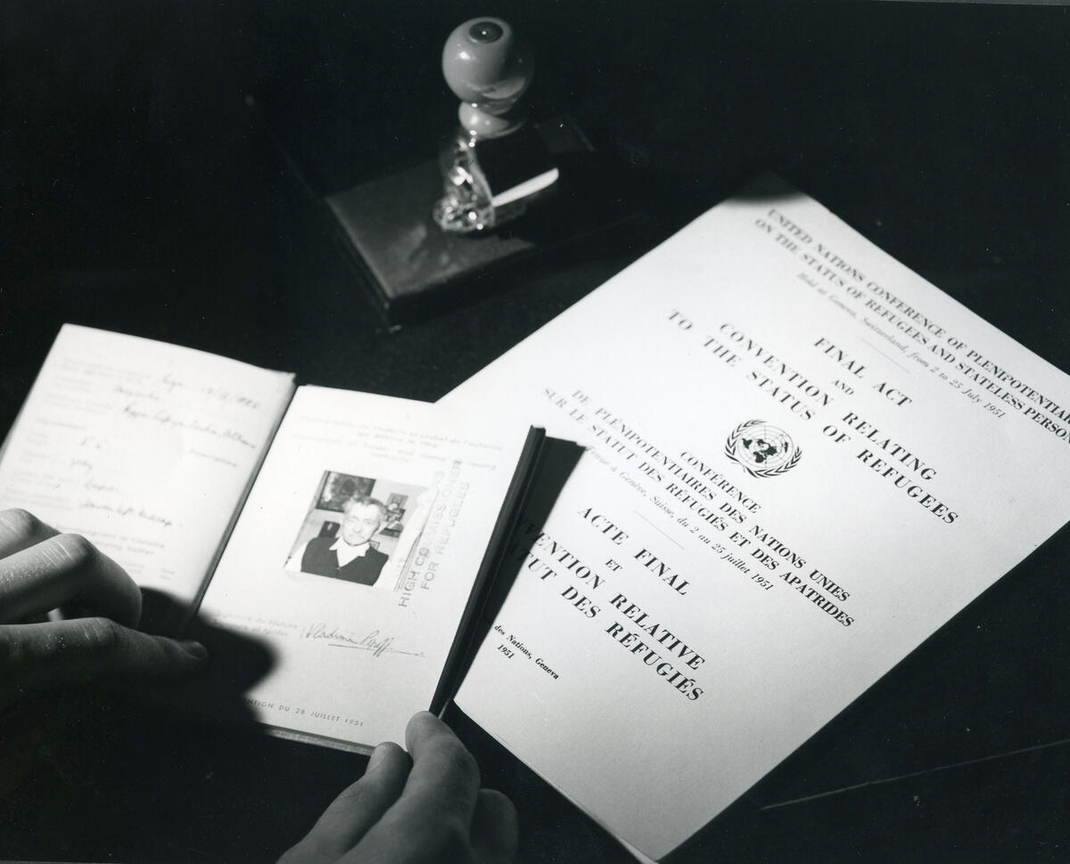 A black and white photo showing travel documents and The Convention Relating to the Status of Refugees.