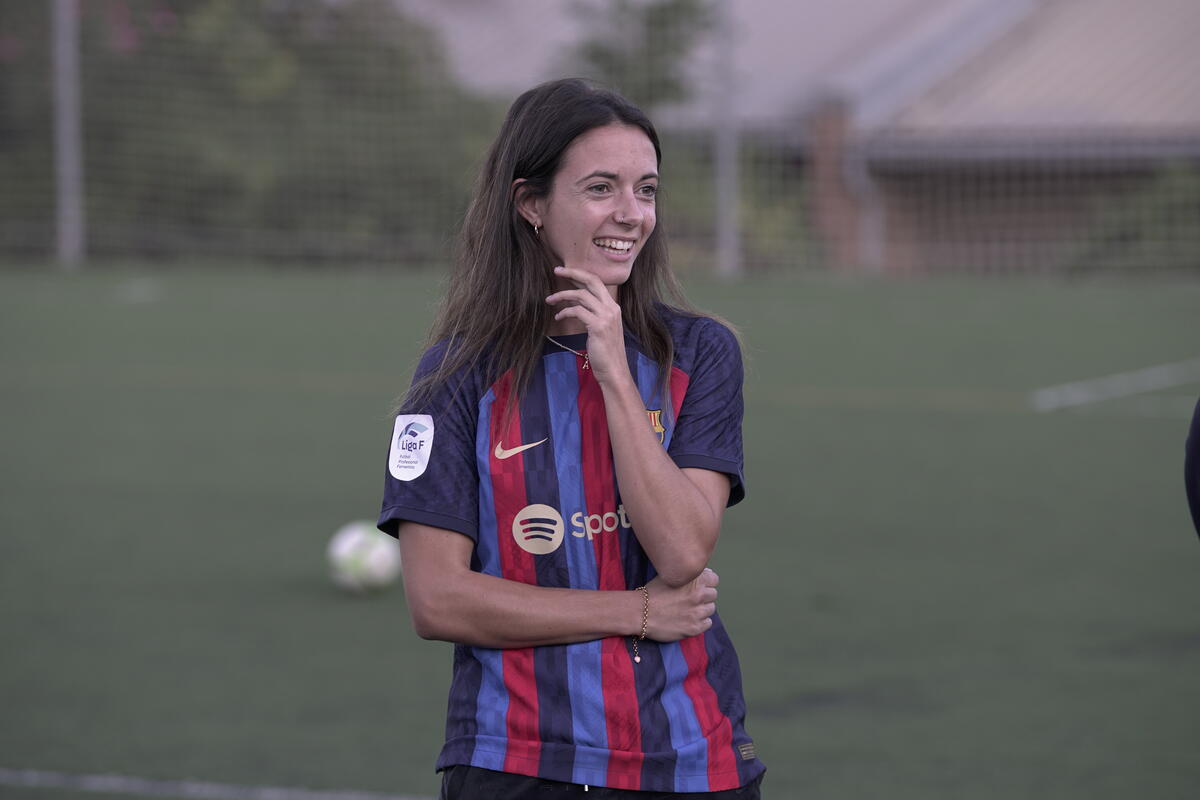 Aitana Bonmatí in football attire smiling on the football field