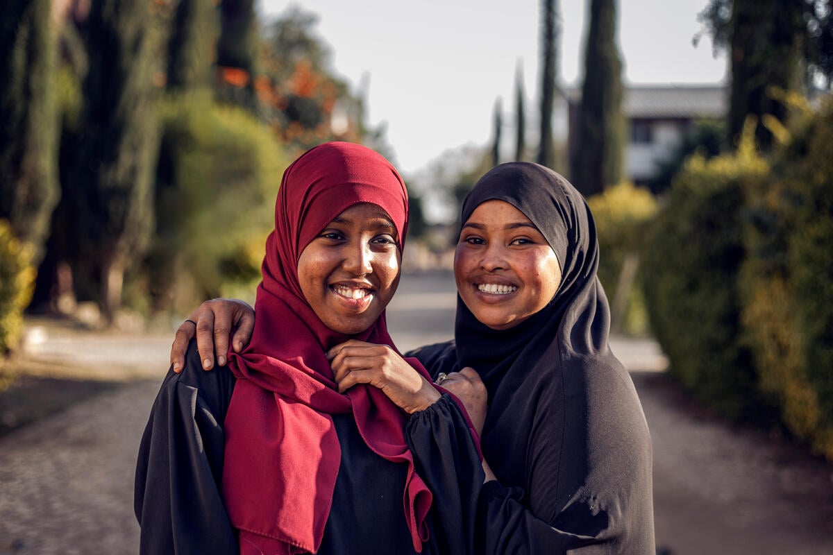 Two young women smile at the camera.