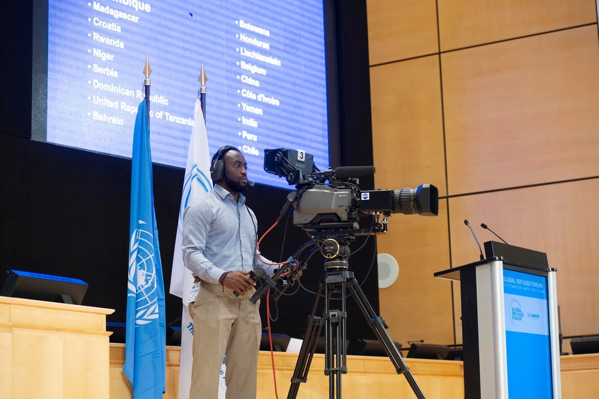 A cameraman films from the stage at the Palais des Nations.