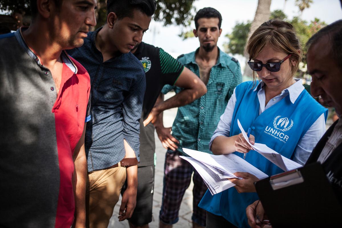 UNHCR staffer helps refugees and migrants to register at the local police station on Kos Island in Greece.