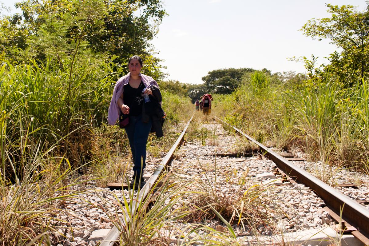 A woman fleeing El Salvador walks along the train tracks in Chiapas, Mexico.