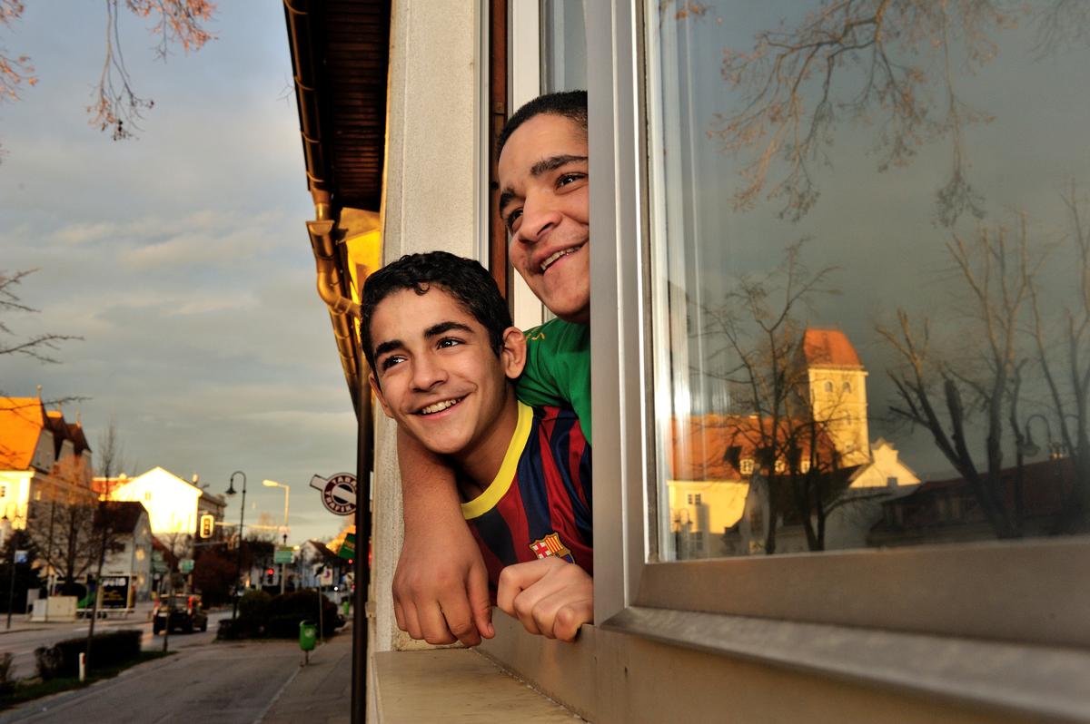 Austria. Syrian refugee kids looking out from their new home in a small town. They are on a resettlement program for Syrian refugees, in cooperation with UNHCR