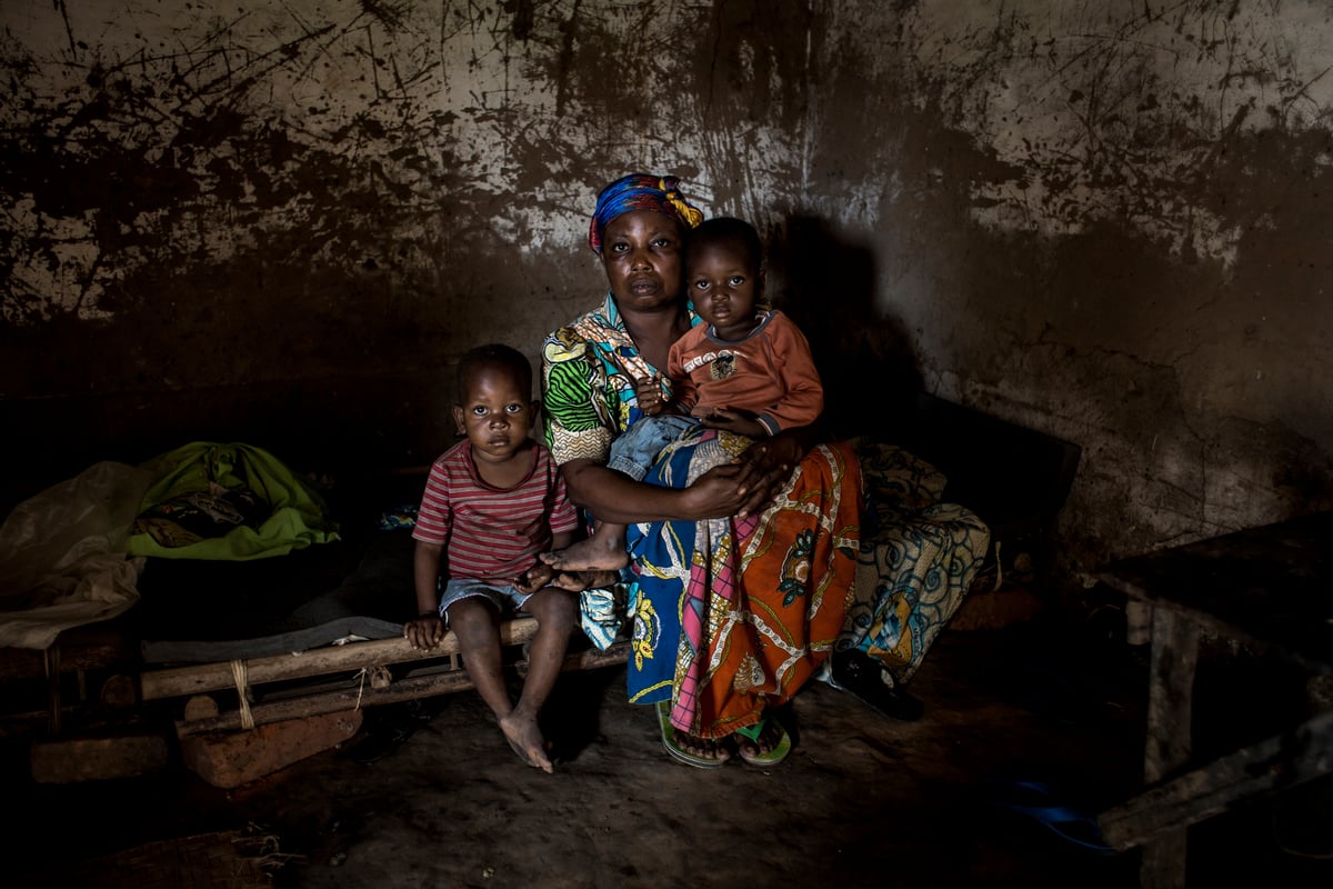 Democratic Republic of Congo. An internally displaced women sits with children in her house that was destroyed during fighting.