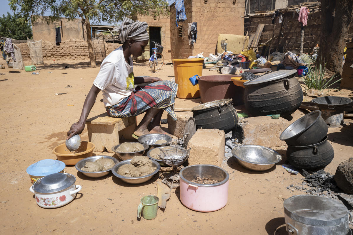 A displaced woman cooks food at a relative's house in Kaya, Burkina Faso.