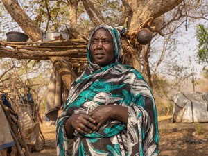A Sudanese woman in front of a shelter