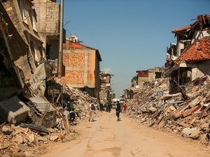 Residents walk past the rubble of destroyed buildings shortly after the earthquakes in Hatay, Türkiye.