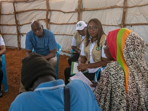 A group of people having a discussion inside a huge shelter