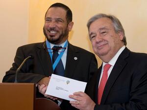 António Guterres, the UN High Commissioner for Refugees, holds the cheque he has just received from Abdullah Al-Matouq, advisor to the Emir of Kuwait.
