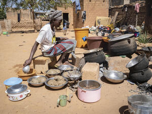 A displaced woman cooks food at a relative's house in Kaya, Burkina Faso. 