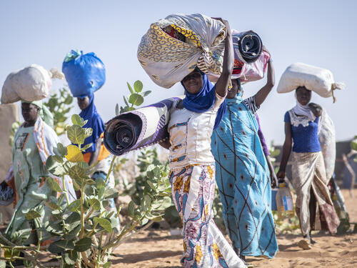 Malian refugee women carrying their belongings through Mbera refugee camp in Mali. UNHCR, UN Refugee Agency, Sexual and Gender-based Violence SGBV GBV