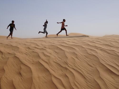 Young children from the Sahrawi community play on the sand dunes at Dakhla camp in Tindouf, western Algeria, close to the border with Morocco and Western Sahara.