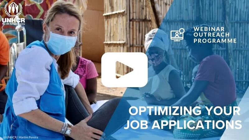 A UNHCR staff member sits with three women
