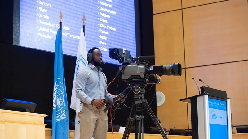 A cameraman films from the stage at the Palais des Nations. 