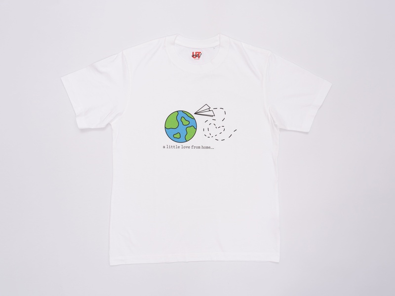 A white t-shirt with an illustration of the Earth and a paper plane flying around it