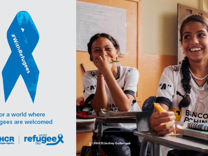 On the right, a picture of two young girls smiling and sitting at their desks in a classroom. On the left, a blue ribbon with the inscription "With Refugees". Text under the ribbon reads: "For a world where refugees are welcome".