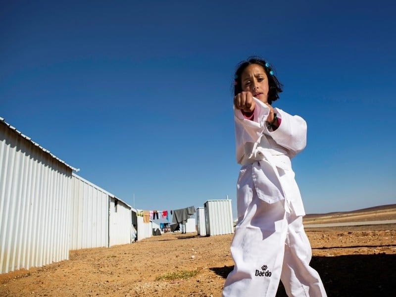 A young girl practices karate moves.