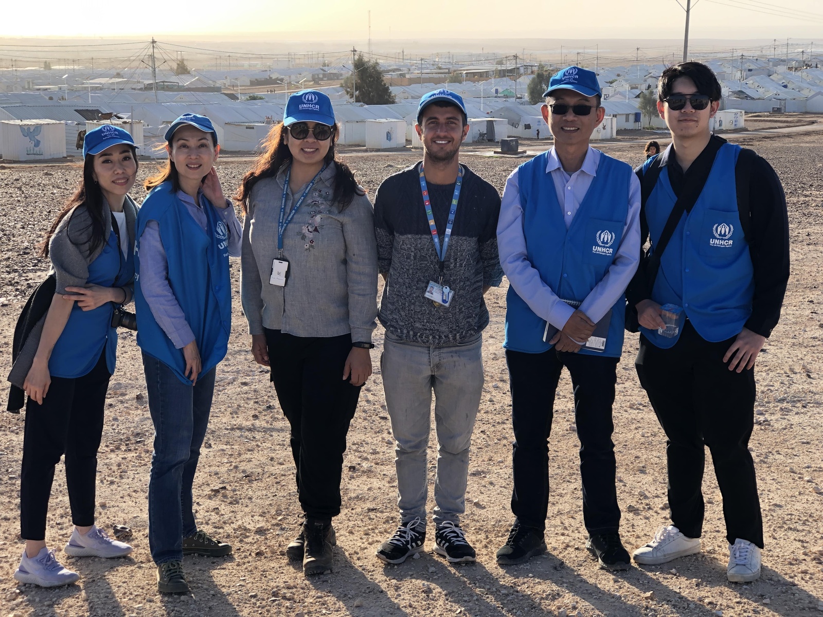 Mr. Wanchai Tachavejnukul standing next to UNHCR staff members