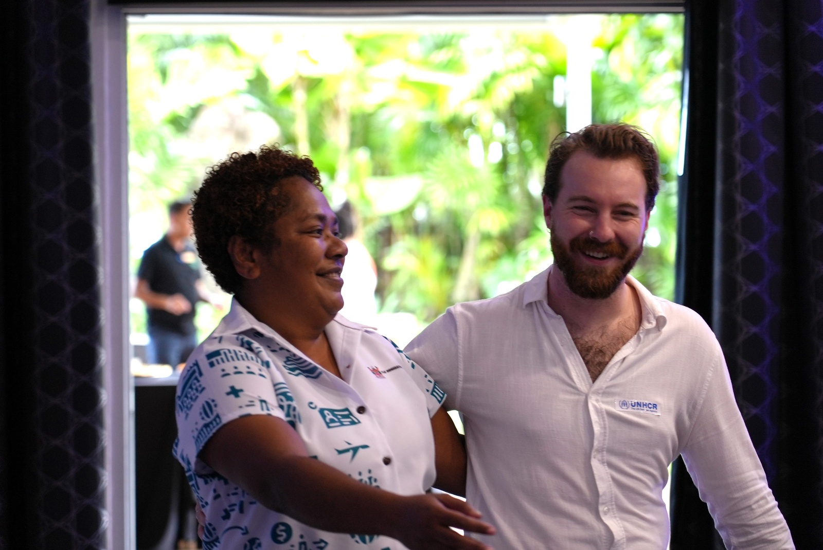 UNHCR and Fiji Immigration staff member celebrate arm in arm