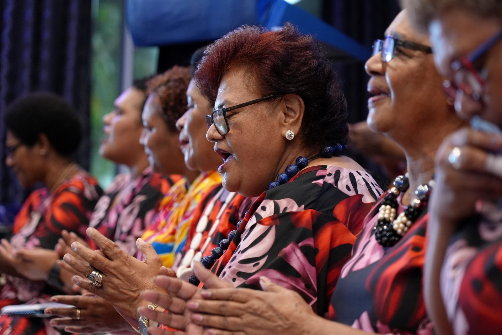 Choir members sing and clap their hands