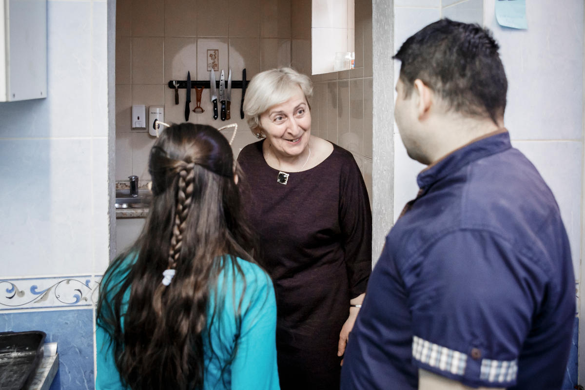 Belarus. A former Georgian refugee shows the kitchen of her own café to a Syrian refugee chef