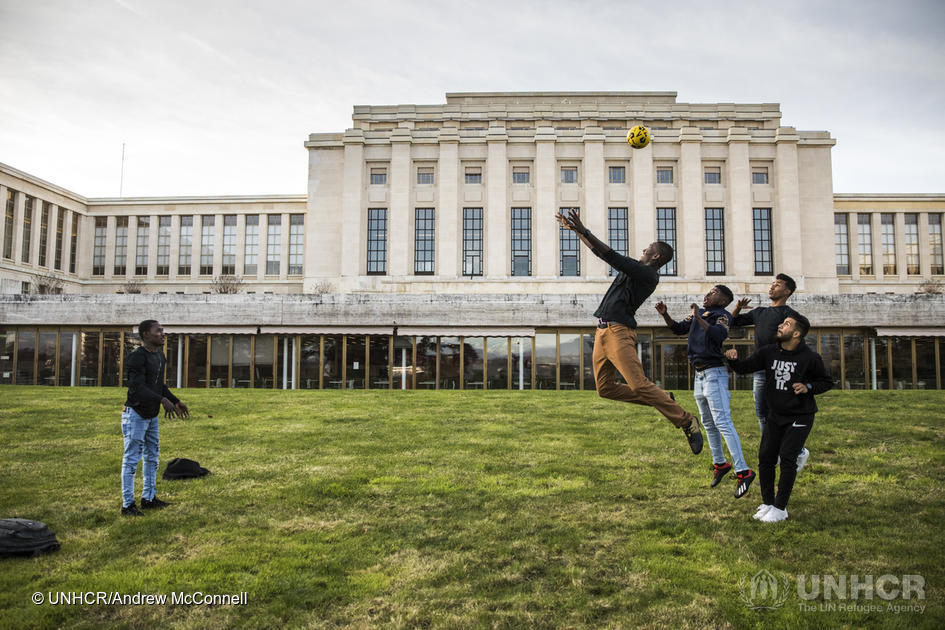 Refugees and asylum-seekers attending events during the Global Refugee Forum play football on the lawn at the Palais des Nations.