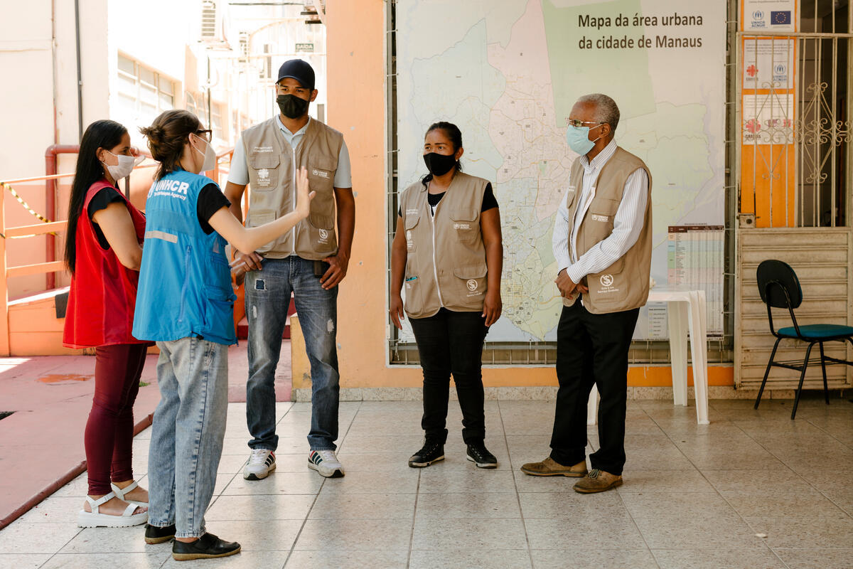 Lucetti (in red) chats with her fellow humanitarian workers at Caritas' Manaus headquarters.