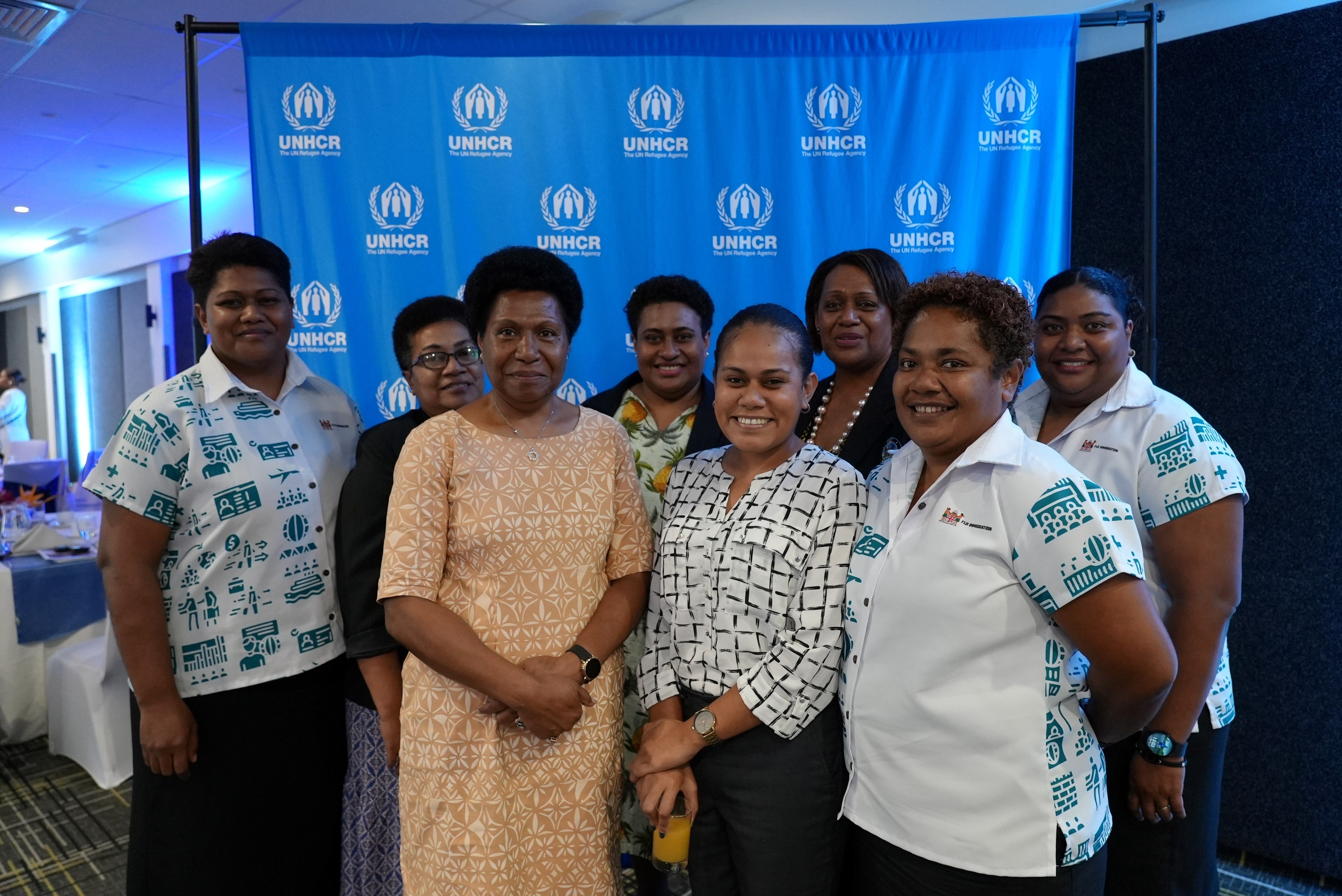 Group of immigration staff smile at the camera
